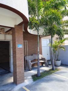 a building with palm trees in a parking lot at Pousada Nilza Mar in Maceió