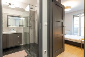 y baño con ducha y lavamanos. en Apartament Koncertowy, en Białystok