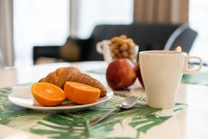 talerz pomarańczy i filiżankę kawy na stole w obiekcie Platinum Towers Central Apartments w Warszawie