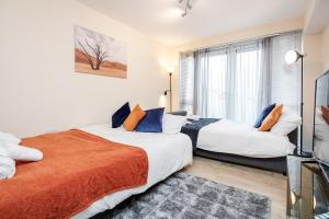 two beds in a room with a window at MPL Apartments Watford-Croxley Biz Parks Corporate Lets 2 bed FREE Parking in Watford