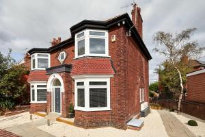 a red brick house with white windows on it at Coppergate Mews Apartment 2 in Doncaster