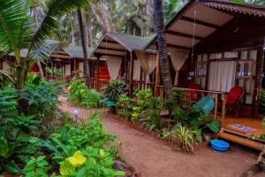 a house with a lot of plants in front of it at Jardim a Mar in Agonda