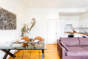倫敦的住宿－Bright and Spacious Notting Hill Nest，客厅配有桌子和紫色沙发