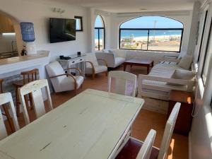 una sala de estar con una mesa y sillas en Bahía de Rosas frente al mar Algarrobo Norte, en Algarrobo