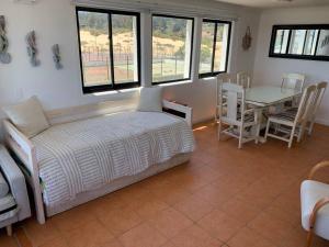 Un dormitorio con una cama y una mesa y sillas. en Bahía de Rosas frente al mar Algarrobo Norte, en Algarrobo 23 fotos más
