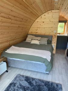 a bedroom with a bed in a wooden cabin at Fernhill Valley Farm in Blaencwm
