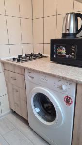 uma cozinha com uma máquina de lavar roupa e uma chaleira. em Квартира 1-кімнатна в центрі Миргорода. em Myrhorod