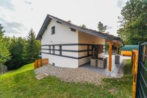 ein weißes Haus mit einem schwarzen und weißen Streifen in der Unterkunft Ferienhaus in Niederösterreich mit 3 Apartments mitten im Wald in Feichtenbach