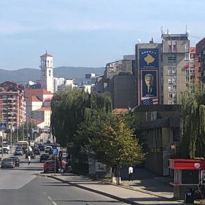 ulica miejska z budynkiem z napisem w obiekcie Lion Apartment - close to Prishtina center w Prisztinie