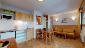 cocina y sala de estar con sofá y mesa en La Grive FAMILLE & MONTAGNE studios 4pers by Alpvision Residences en Chamrousse