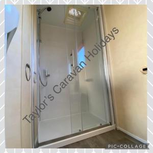 a shower with a glass door in a bathroom at Taylor's Caravan Holiday's 8 Berth (Coral Beach) in Ingoldmells