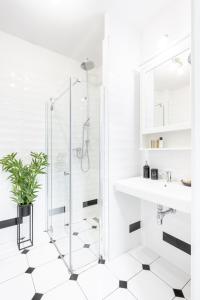 a white bathroom with a shower and a sink at Apartament Onyks in Zakopane