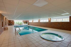 a large swimming pool with a hot tub in a building at Balgavies Home Farm - Cottage in Forfar