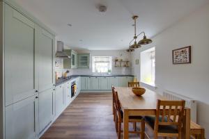 a kitchen with a wooden table and a dining room at Balgavies Home Farm - Cottage in Forfar