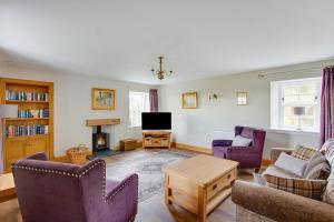 a living room with a couch and chairs and a tv at Balgavies Home Farm - Cottage in Forfar