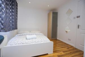a white bedroom with a white bed in it at Fabulous Room with en-suite bathroom and shared kitchen in Thamesmead