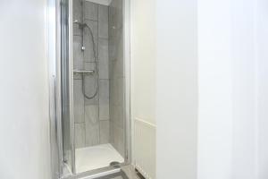 a shower with a glass door in a bathroom at Fabulous Room with en-suite bathroom and shared kitchen in Thamesmead +12 photos