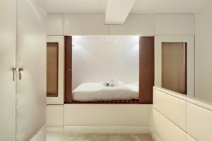 Loft center of Paris by Studio prestige في باريس: غرفة نوم بسرير ومرآة