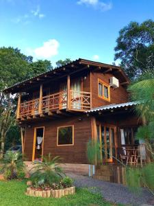 プライア・グランデにあるPousada Village dos Canyonsの木造の家屋で、バルコニーが付いています。
