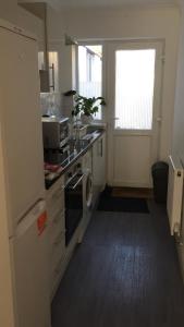 a kitchen with a washer and dryer and a window at Quiet Studio by Lloyd Park in South Norwood