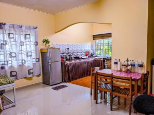 a kitchen with a table and a refrigerator at Homestay Kak soh at KampungKalai, Jeli Kelantan in Jeli