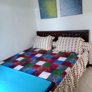 ein Schlafzimmer mit einem Bett mit einer bunten Decke darauf in der Unterkunft Kalandra Guest House in Ponorogo