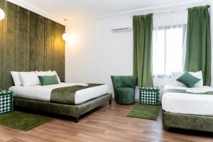 a hotel room with two beds and a chair at Hotel Majestic in Casablanca