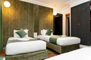 two beds in a hotel room with two beds at Hotel Majestic in Casablanca