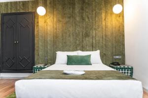a bedroom with a large bed with a green pillow at Hotel Majestic in Casablanca