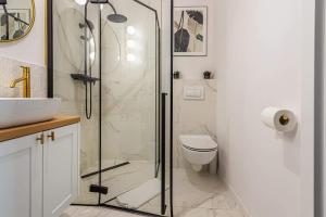 a bathroom with a shower and a toilet and a sink at Apartament KASHMIR in Gdańsk