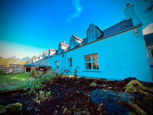 a white house with a blue facade at No 4 old post office row Isle of Skye - Book Now! in Eyre