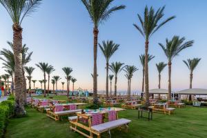 a row of tables and palm trees at the beach at Rixos Premium Seagate in Sharm El Sheikh