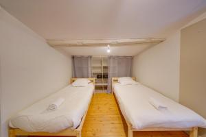 two beds in a small room with white walls at Observance 2 bedroom duplex apartment in Bordeaux