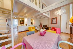 a living room with a table with a pink table cloth at Observance 2 bedroom duplex apartment in Bordeaux