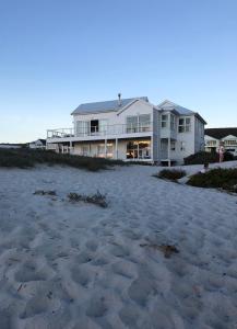 a large house on the beach with a sandy beach at Thyme & Tide Beach Villa in Yzerfontein