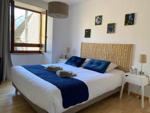 a bedroom with a large bed with blue pillows at Auberge du Grand Champ in Lalley