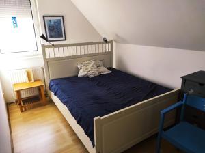 a bedroom with a bed with a blue comforter at Sunhouse, Balatonvilágos in Balatonvilágos