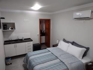 Ipê Suítes في دومينغوس مارتينز: غرفة نوم بسرير ومغسلة