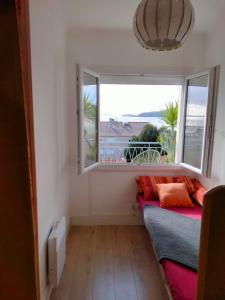 um quarto com uma janela e um sofá com almofadas em Superbe Appartement avec terrasse vue mer em Le Lavandou