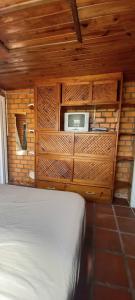 um quarto com uma cama e um micro-ondas na parede em Pousada Moradas da Praia em Garopaba