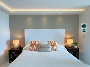 una camera da letto con un grande letto bianco con due lampade di Ocean Front studio , step to the beach a Cul de Sac