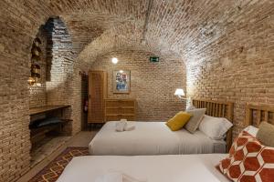 um quarto com 2 camas numa parede de tijolos em BNBHolder Art Loft LA LATINA em Madri