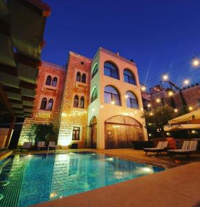a building with a swimming pool at night at Siena Hotel in Jounieh