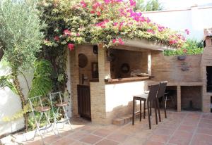a patio with a table and chairs and flowers at Rustic spanish villa Saltwater Pool in Benalmádena