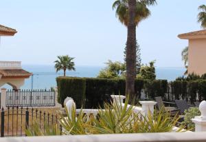 a garden with a palm tree and a fence at Rustic spanish villa Saltwater Pool in Benalmádena