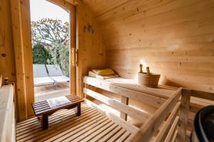 a wooden sauna with a bench and a window at Villa Viola Spa&Garden in Gyula