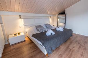 1 dormitorio con 1 cama grande y toallas. en Spacieuse Villa avec vue panoramique sur le lac, une Exclusivite LLA Selections by Location Lac Annecy, en Doussard