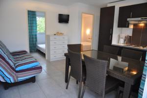 a kitchen and dining room with a table and chairs at Residence de tourisme Le clos des Vendanges in Moriani Plage