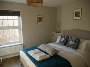 1 dormitorio con cama y ventana en The Fox and Hounds en Whittlebury