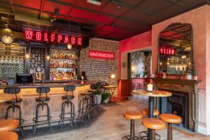 a bar with wooden tables and stools in a restaurant at The Wolfpack Inn in London